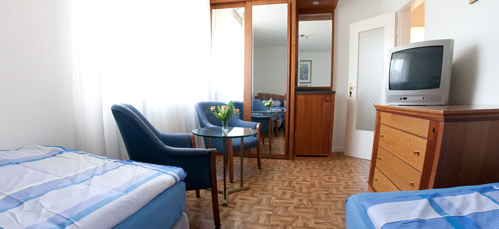 Zimmer mit Fernseher und Sitzgruppe