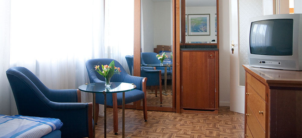 Sitzgruppe mit Fernseher und Spiegelschrank